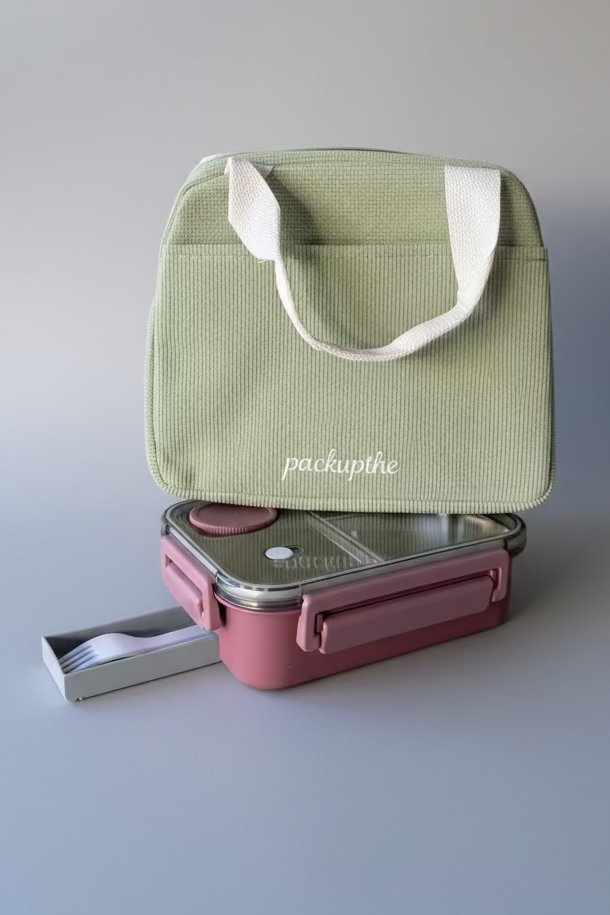 A sage green corduroy lunch bag with cream handles and the brand name 'packupthe' printed on the front, displayed on top of a pink compartment bento box with a fork pulled out.